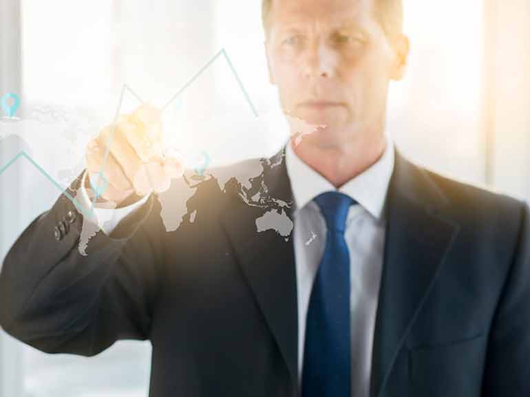 Hombre de negocios dibujando un gráfico en una pizarra de cristal transparente