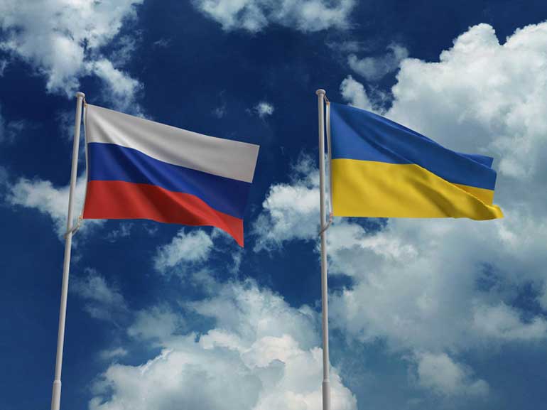 The Russian and Ukrainian flag next to each other waving on a blue sky background