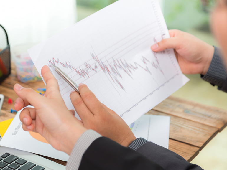 Businessman looking at a paper with graphs