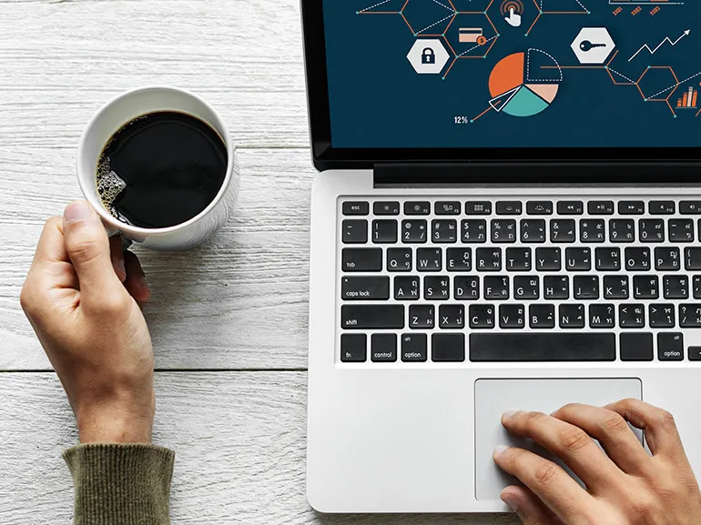 Person mit Laptop zum Analysieren von Grafiken und Diagrammen