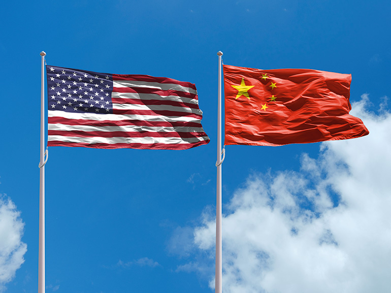 US and China flags with a blue sky background