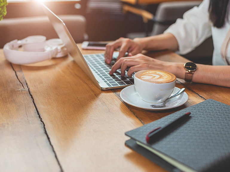 امرأة على الكمبيوتر المحمول مع القهوة، وتحليل السوق