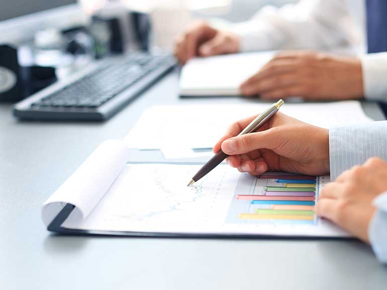 Empresarios analizando gráficos de papel en un portapapeles