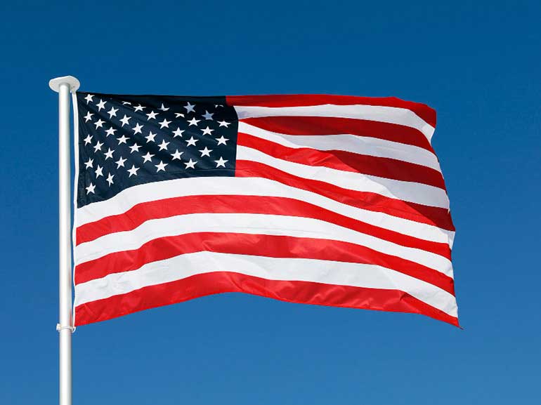 A waving US flag on a blue sky background