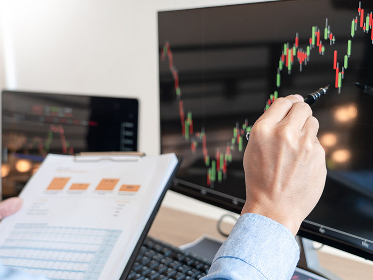 Händler, der Finanzdaten, Diagramme und Berichte auf einem Bildschirm analysiert