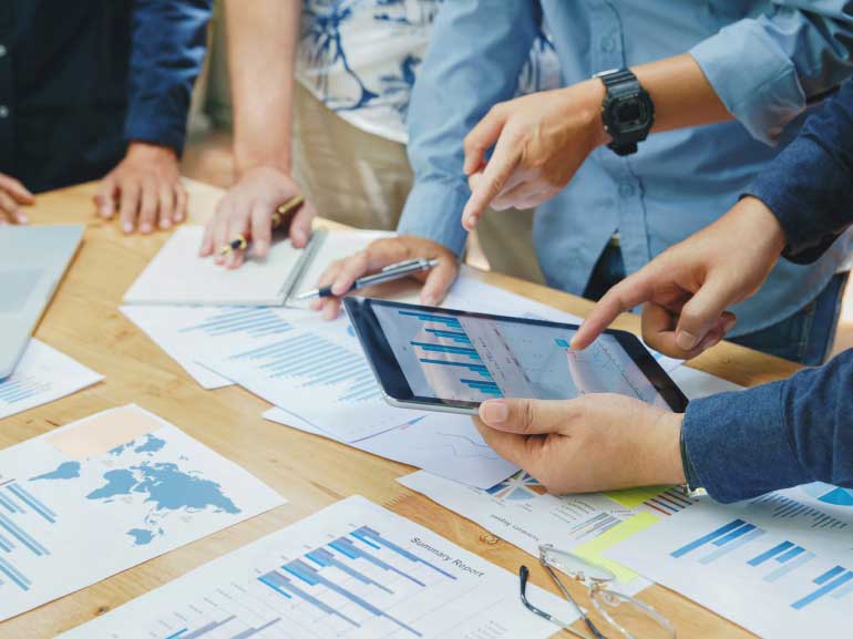 Colaboración en equipo para debatir y analizar cuadros y gráficos empresariales