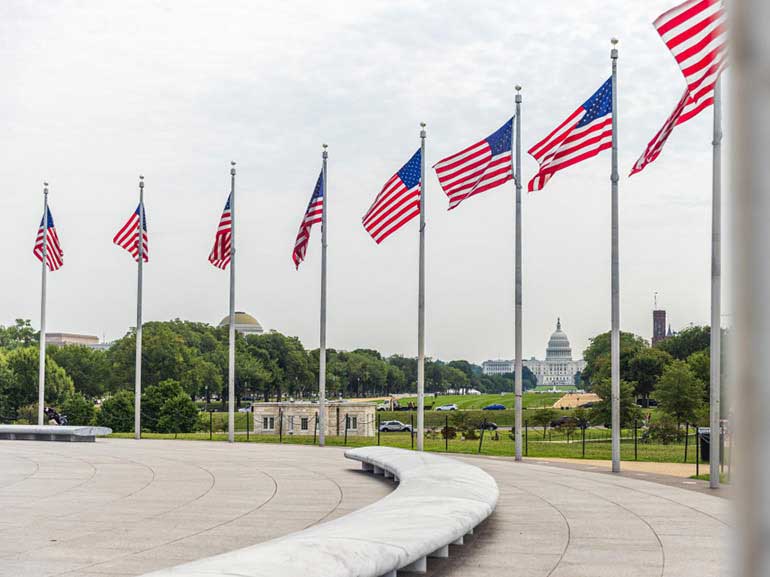 Banderas estadounidenses ondeando en Washington DC, Estados Unidos, sobre el fondo del edificio del Capitolio
