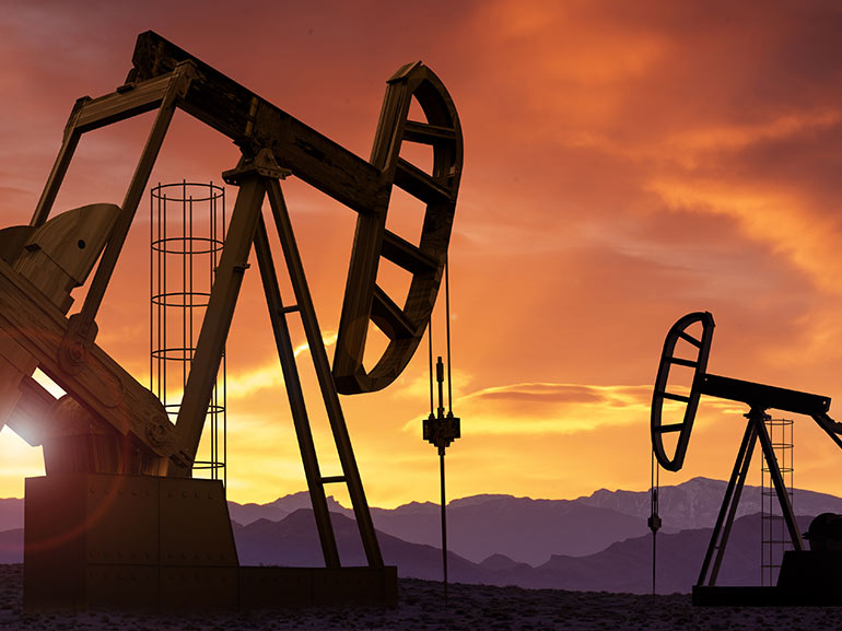 Dos excavadoras de petróleo al atardecer