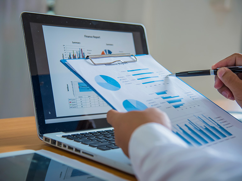 Geschäftsmann, der an einem Laptop arbeitet und sich ein Datendokument mit einer Grafik ansieht