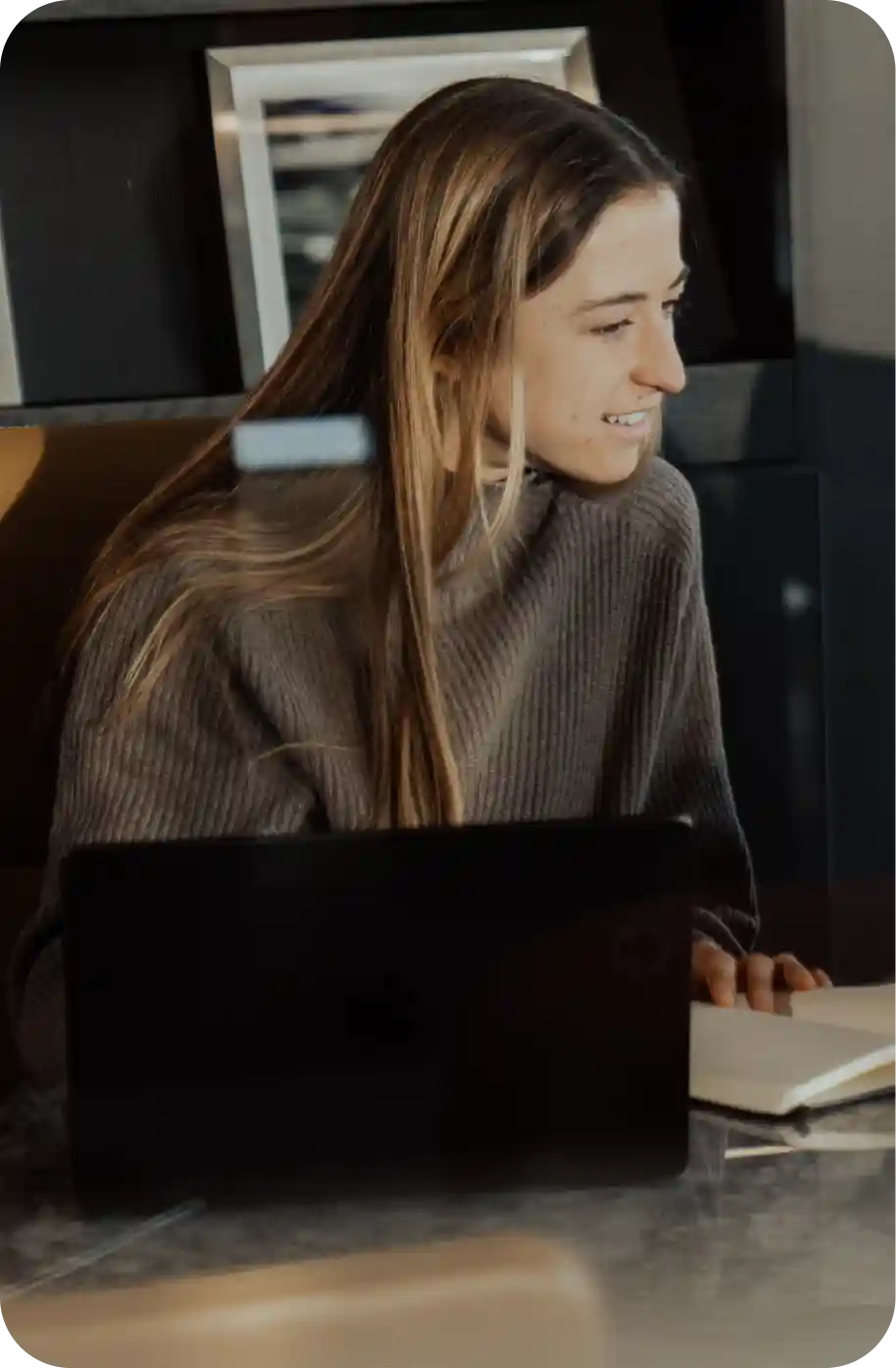 WHOOP team member working on a laptop and reviewing notes, reflecting the company’s focus on performance analytics, recovery insights, and wearable health technology innovation.