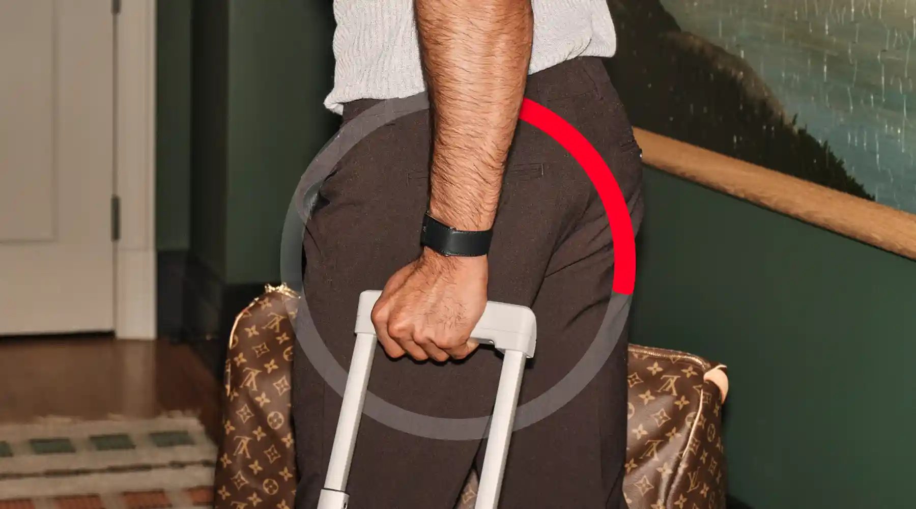A person pushing a suit case with a red recovery dial.