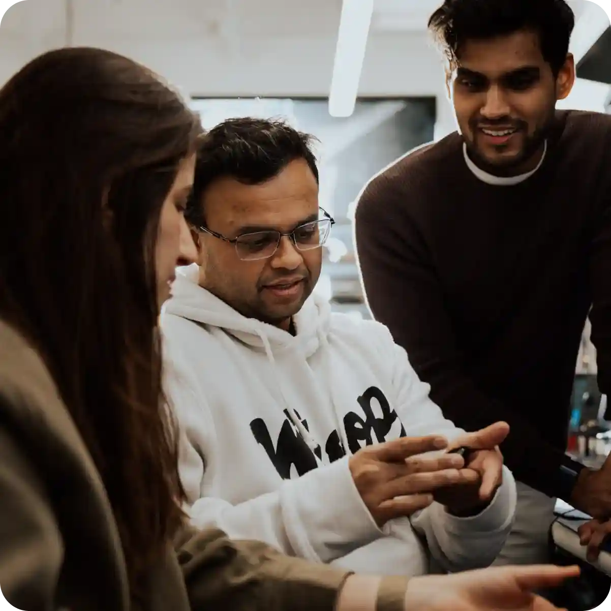 WHOOP team members collaborating on wearable product development, reviewing hardware and performance data to advance recovery tracking and health technology innovation.