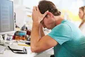 Stressed Man Working At Desk In Busy Creative Office; Shutterstock ID 130606217; PO: The Huffington Post; Job: The Huffington Post; Client: The Huffington Post; Other: The Huffington Post