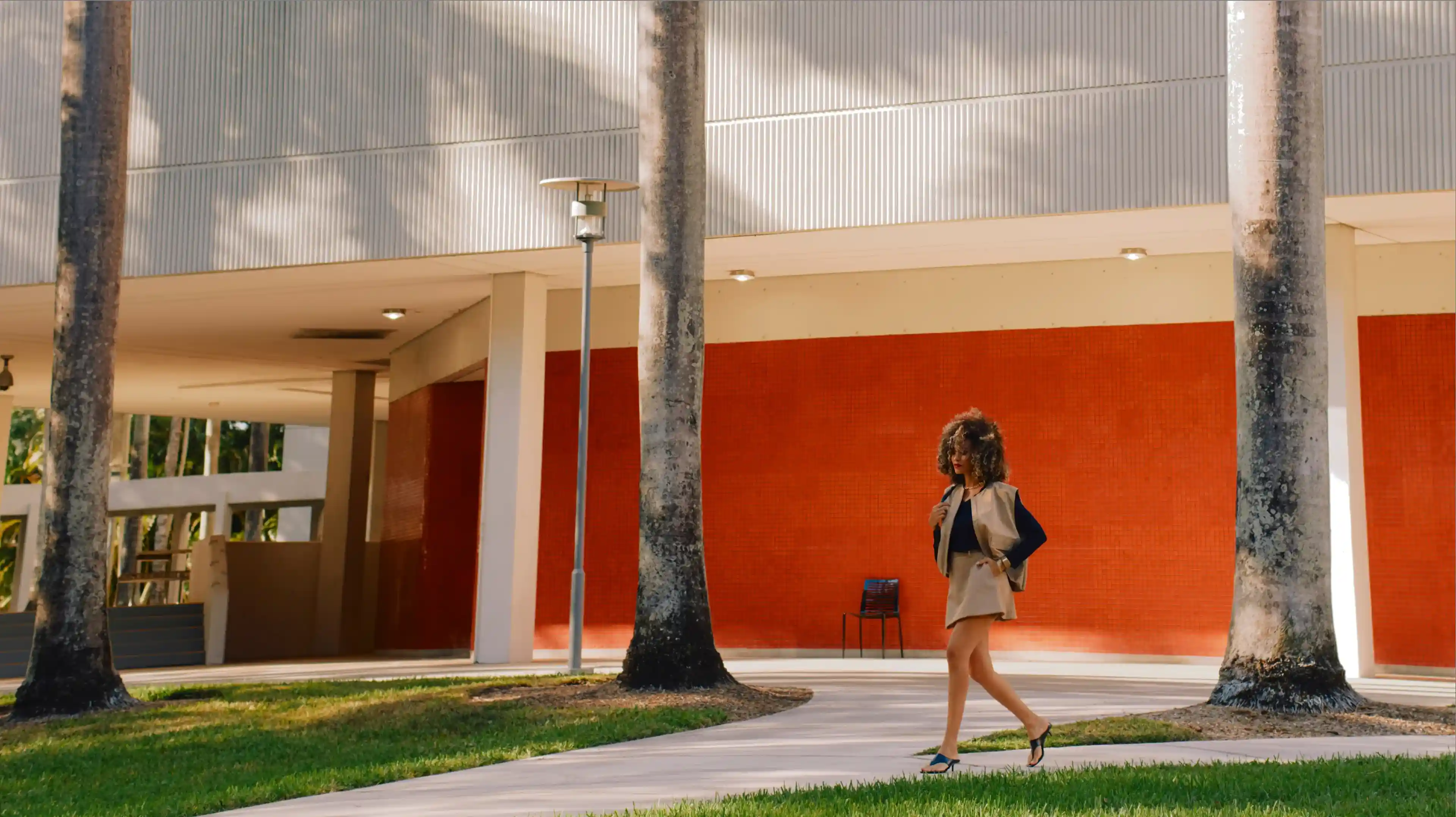 Woman wearing a WHOOP wearable while walking outdoors in an urban setting, highlighting all-day activity tracking, heart rate monitoring, and everyday performance insights.