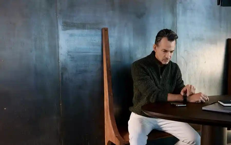 Man using a WHOOP wearable to take an ECG reading at a desk, highlighting heart health monitoring and advanced cardiovascular insights through wearable technology.