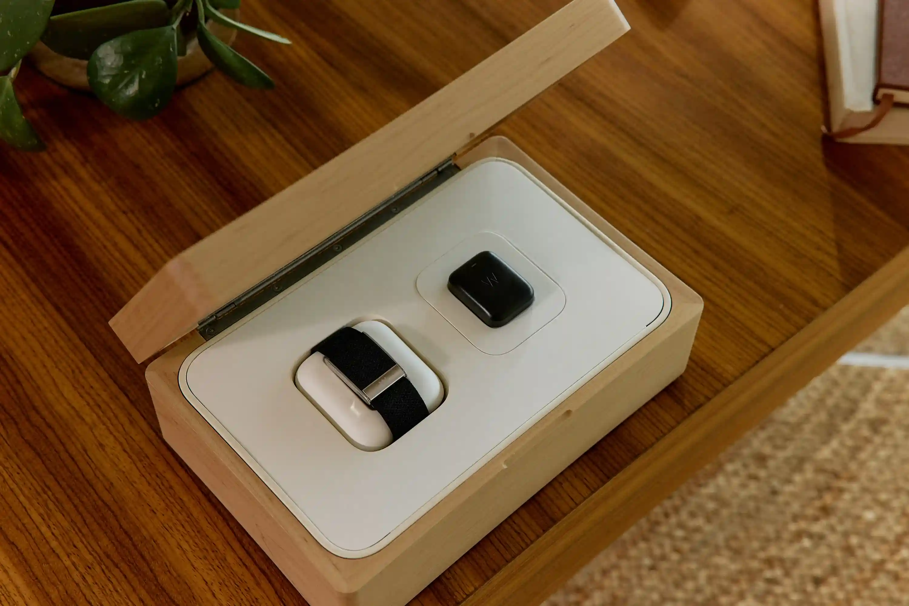 WHOOP 4.0 wearable and battery pack displayed inside a premium wooden box, showcasing the device design and charging system for continuous health and performance tracking.