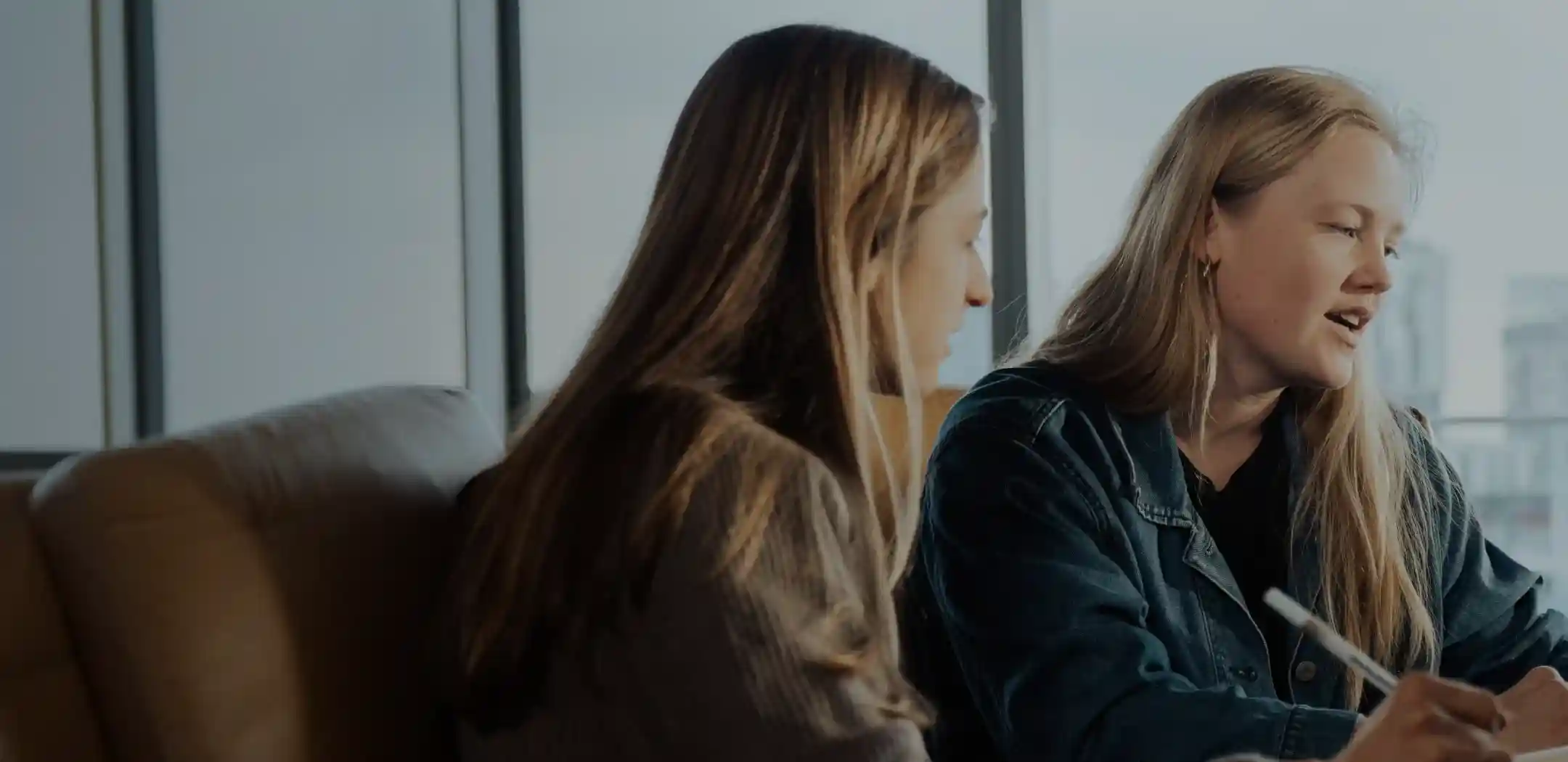 Two WHOOP team members analyzing performance and recovery data together, highlighting WHOOP’s expertise in wearable technology and data-driven health insights.