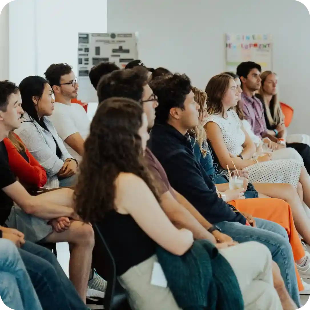 WHOOP team members seated and listening during a company event, highlighting engagement and collaborative workplace culture.