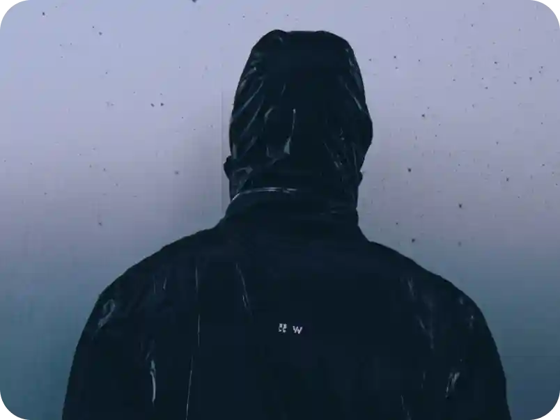 Back view of athlete wearing a black WHOOP hooded training jacket, representing performance-focused design and all-conditions durability.