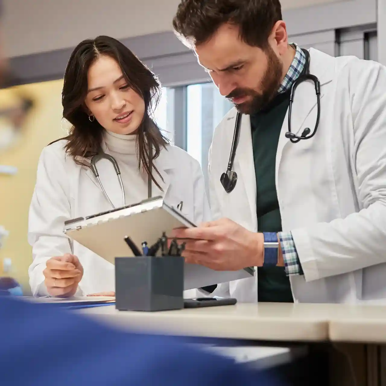 Doctors wearing WHOOP wearables while reviewing clinical health data on a clipboard, highlighting heart health monitoring, biometric insights, and data-driven medical decision-making.