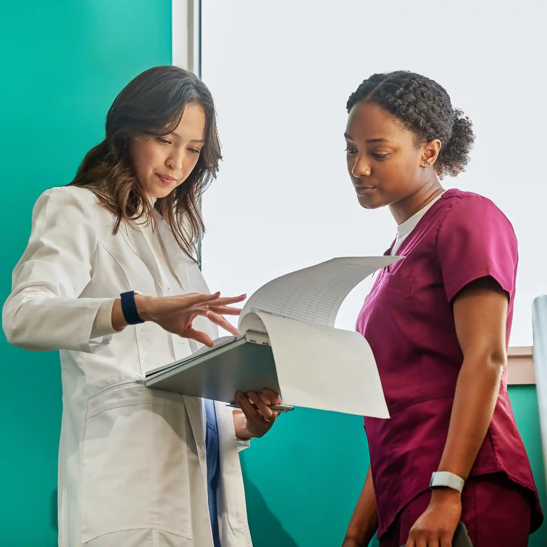 Healthcare professionals wearing WHOOP wearables while reviewing patient health data on a clipboard, highlighting clinical insights, heart health monitoring, and data-driven care.