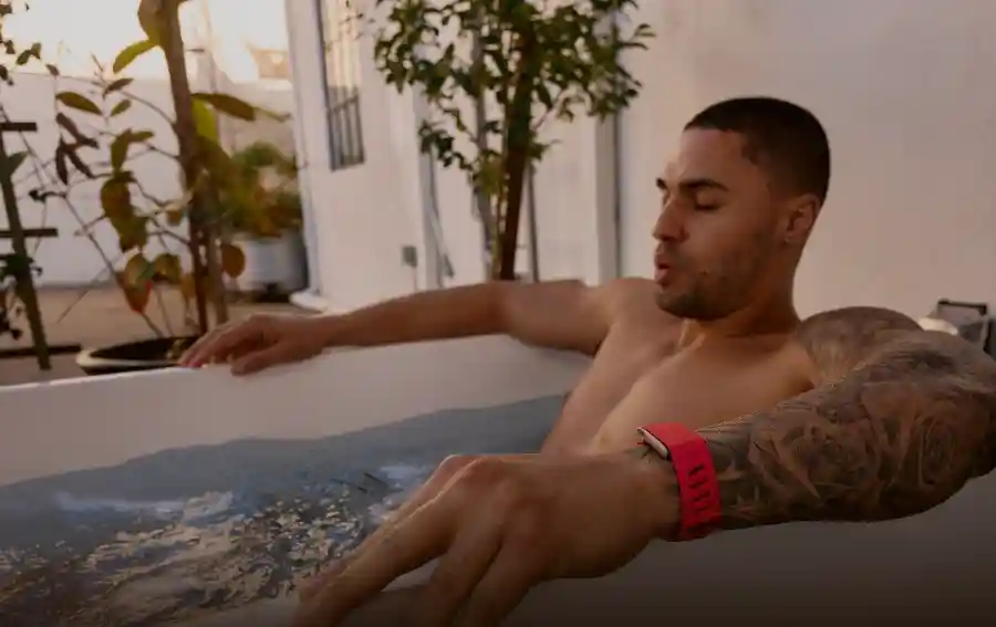 Man wearing a WHOOP wearable during a cold plunge recovery session, highlighting strain tracking, heart rate monitoring, and recovery optimization through hydrotherapy.