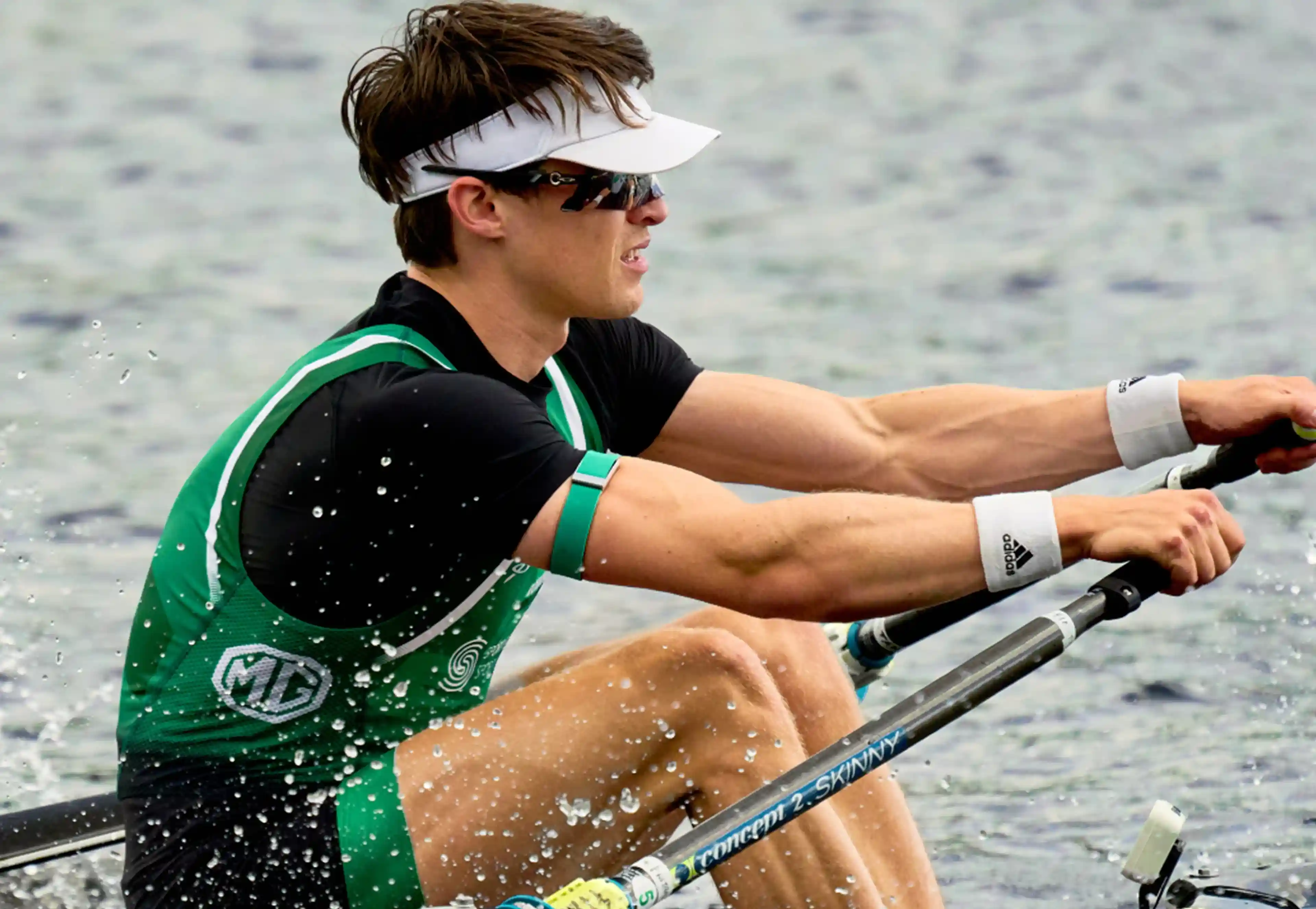 Fintan McCarthy rowing on open water wearing a WHOOP 5.0 band, capturing heart rate, stroke-intensity strain, and recovery signals during endurance training.