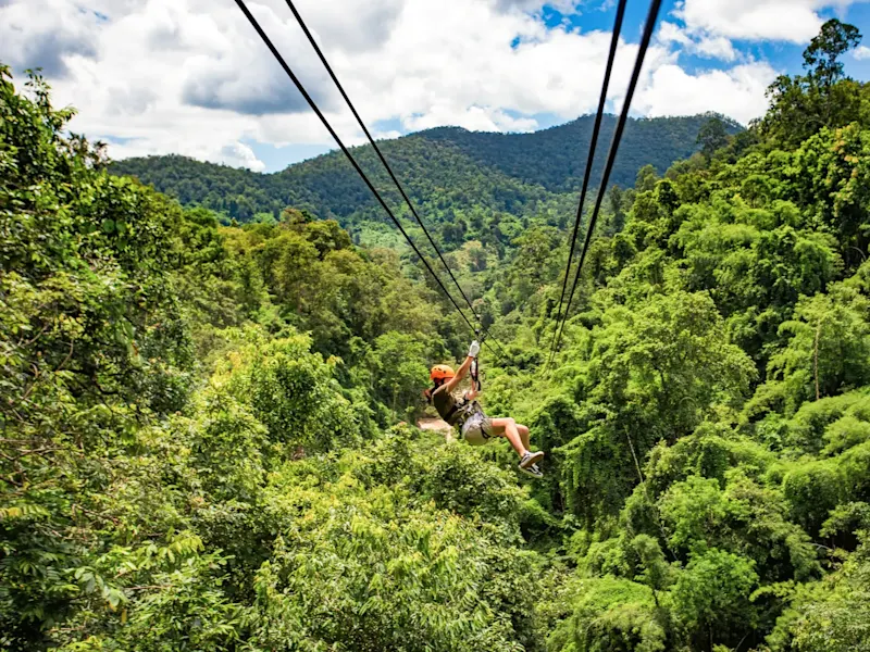Thailande, Phuket, Kathu Personne sur une tyrolienne au-dessus d'une jungle verte. Kathu, Phuket, Thaïlande.
