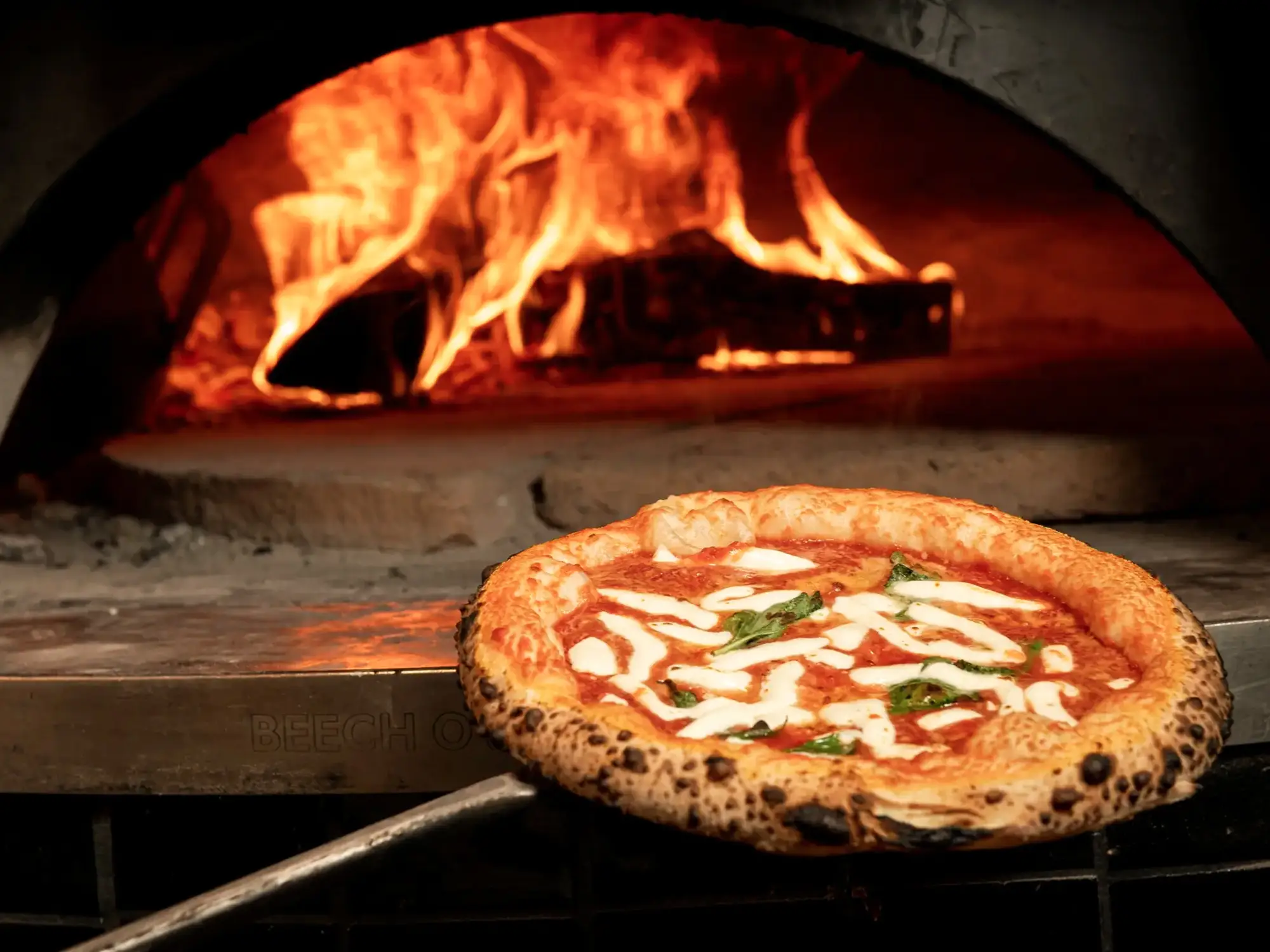 Pizza typiquement napolitaine avec une croûte épaisse cuite au four en pierre