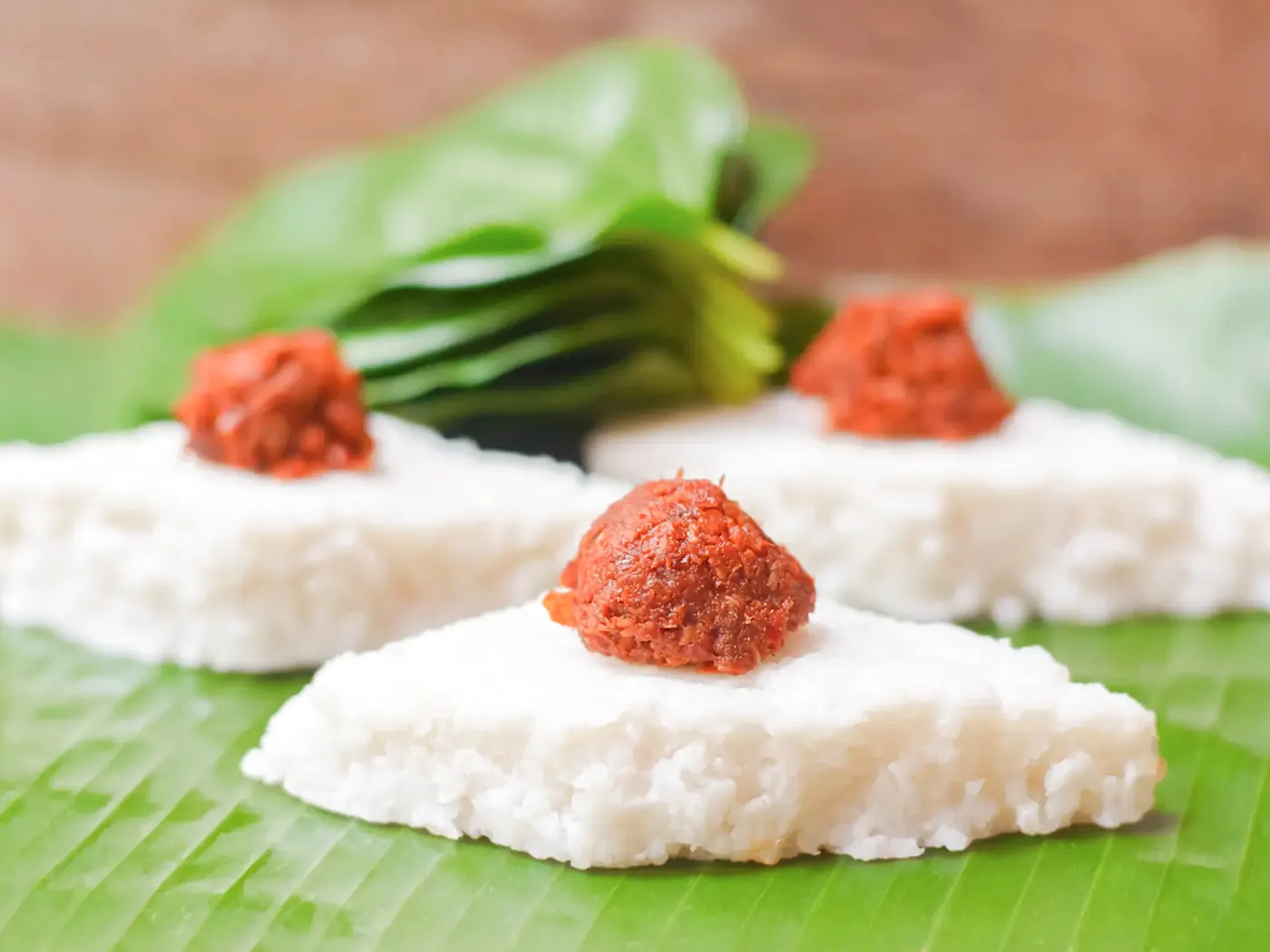 Sri-lankisches Gericht, Kiribath Kiribath, traditioneller Milchreis aus Sri Lanka, mit würzigem Sambol auf frischem Bananenblatt.