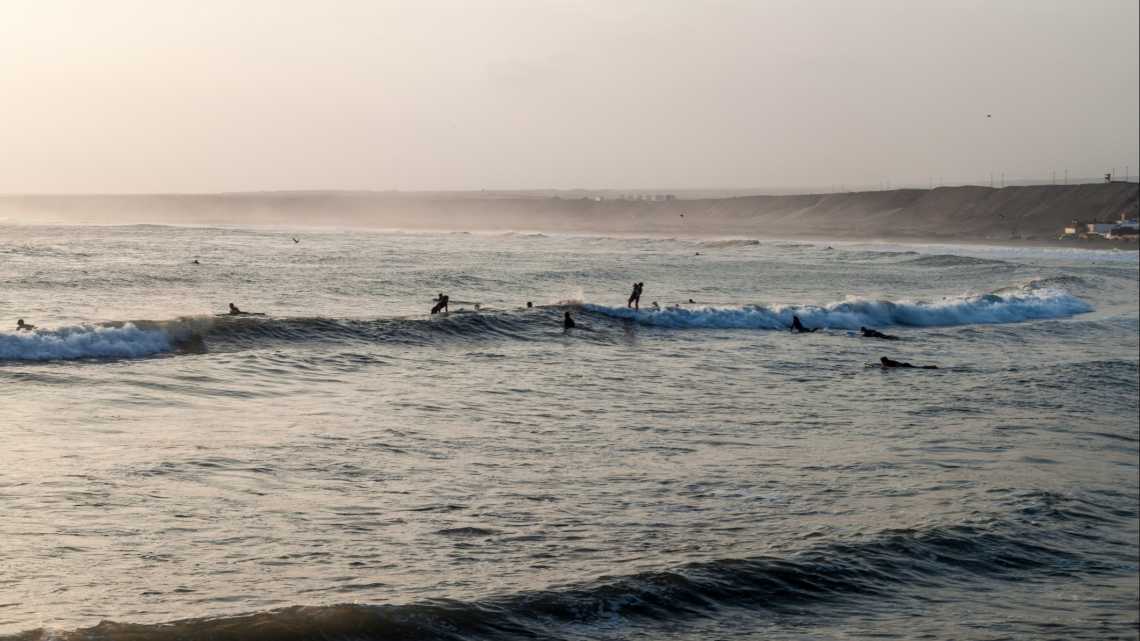 Surfeurs sur la plage de Pacasmayo, Pérou