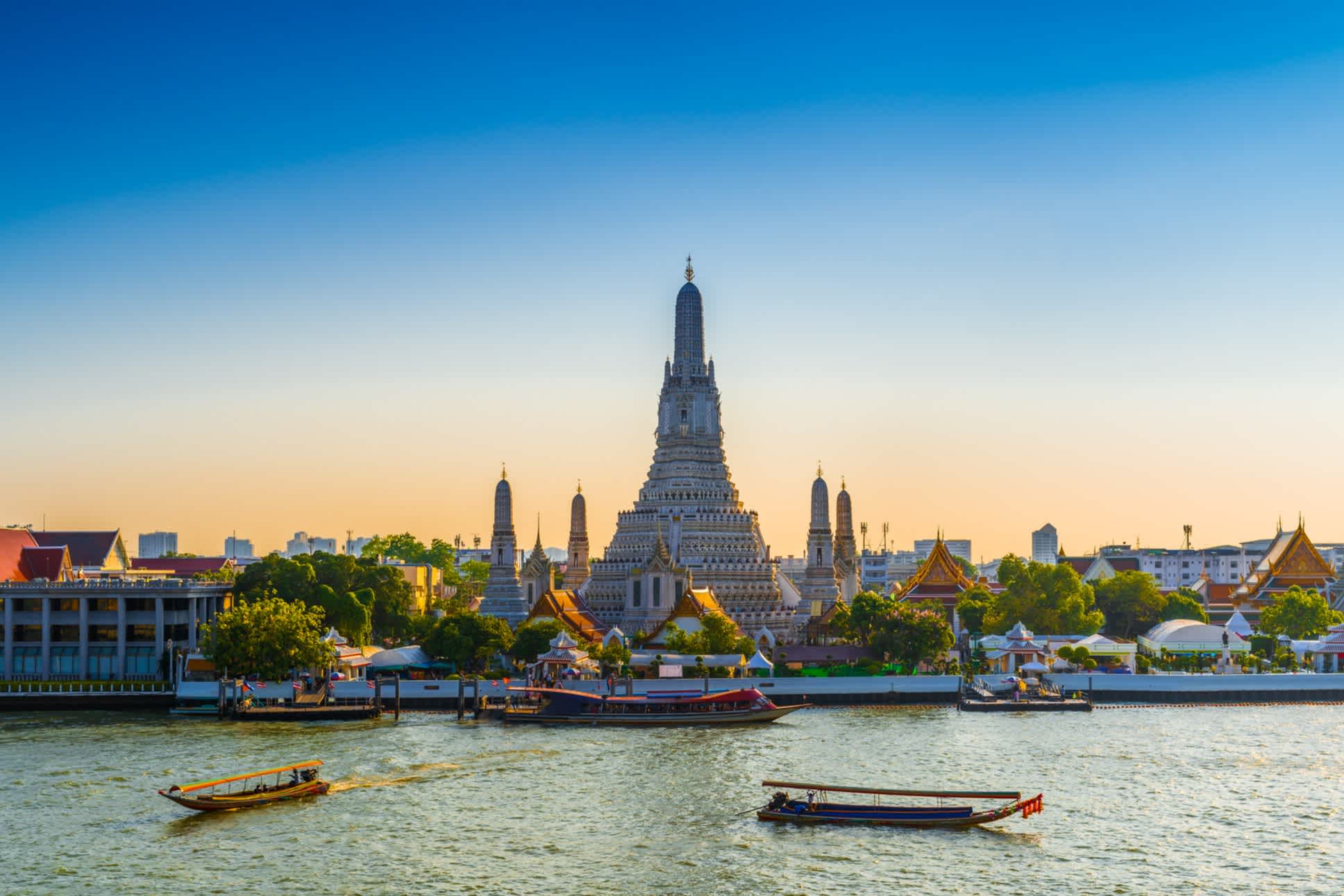 Der Wat Arun Tempel vom Wasser ausgesehen bei Morgenröte