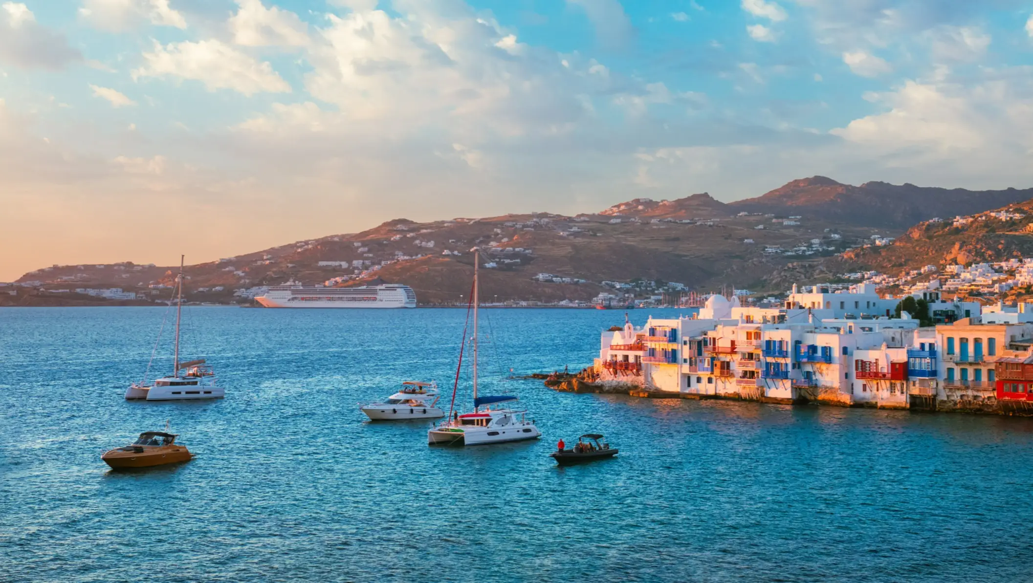 Bateaux de croisières près du port au coucher de soleil à Mykonos, en Grèce