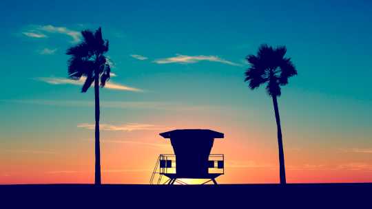 Silhouette d'un cabanon de sauveteur sur une plage en Californie au coucher du soleil