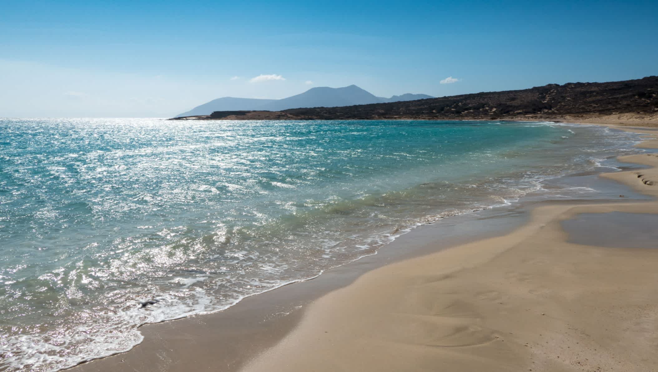 Sable clair et eau turquoise entourés de falaises sur la plage de Pori à Koufonisia, Cyclades, Grèce.
