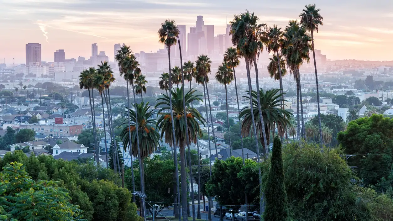 La silhouette de Los Angeles et le centre-ville avec des palmiers au coucher du soleil en Californie, États-Unis