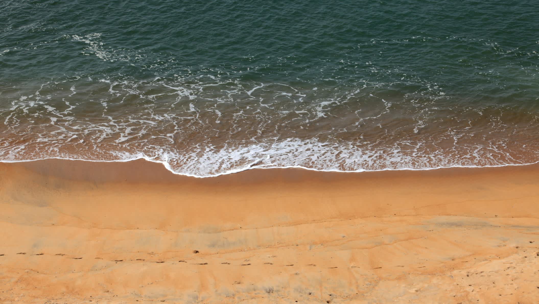Vague sur le sable doré, plage de Bekal, à Kerala, en Inde.