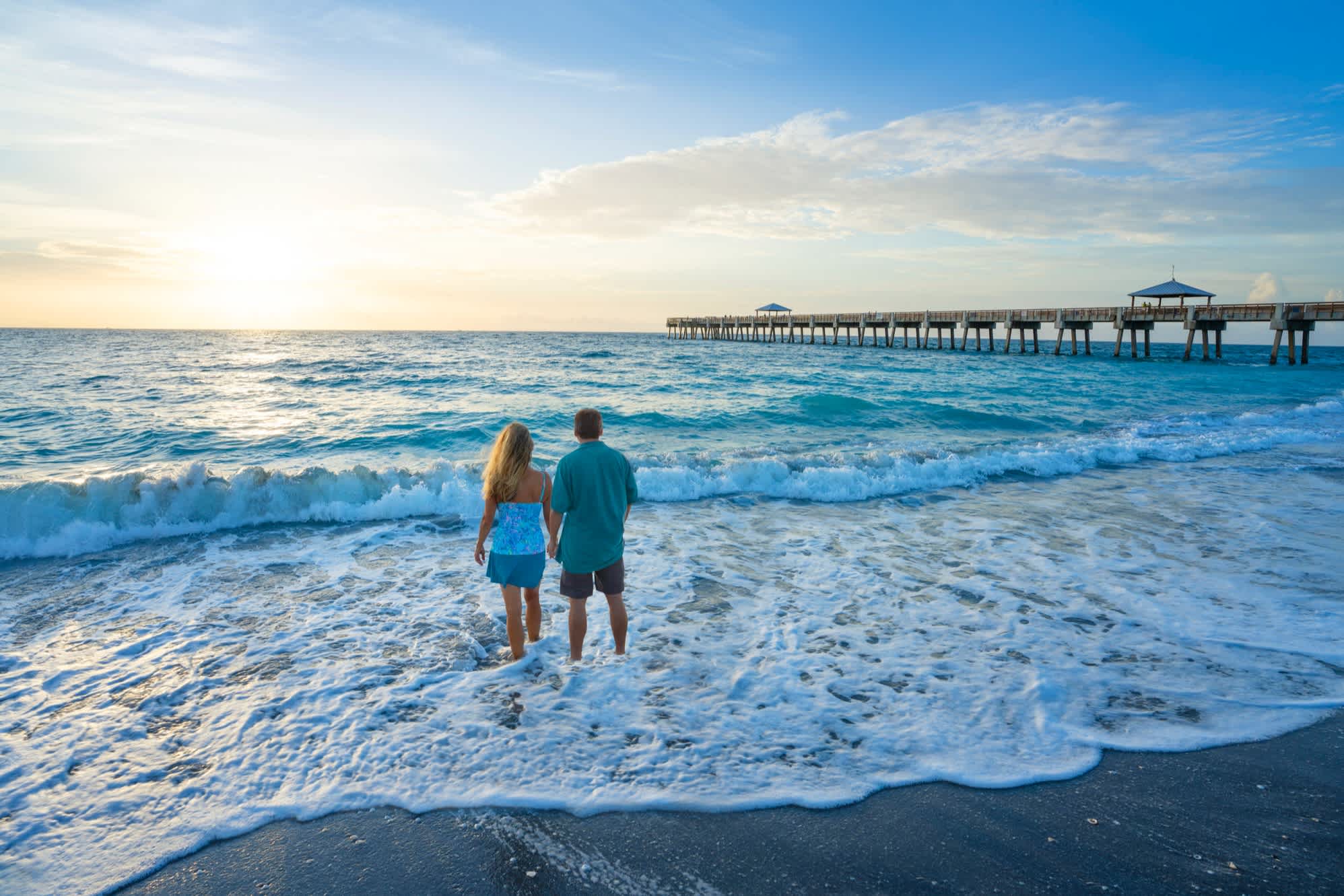 Paar beobachtet den Sonnenaufgang am Strand