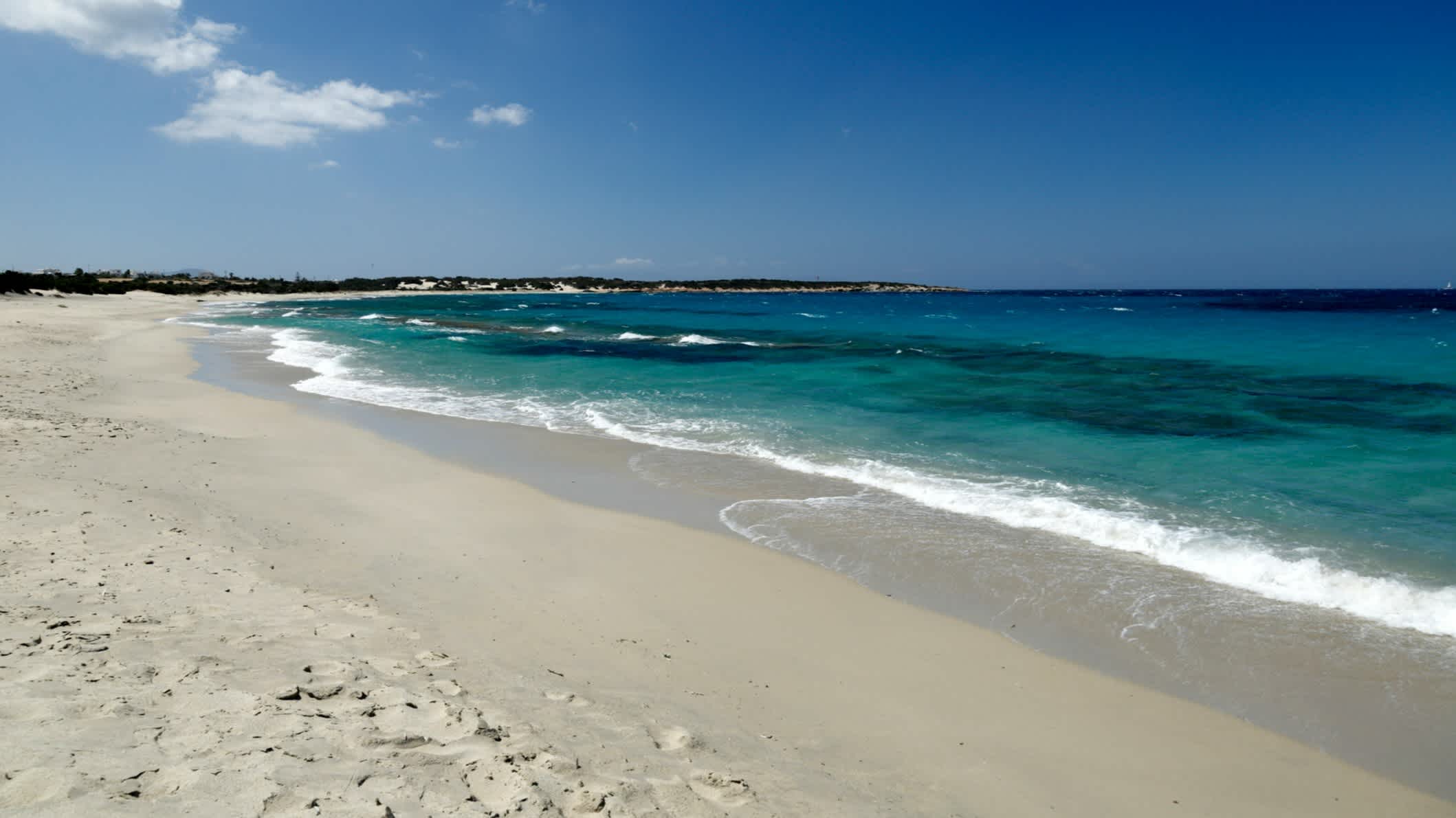 Der Strand Paralia Glyfada auf Naxos, Griechenland, mit weißem Sand und azurblauem Meer. 