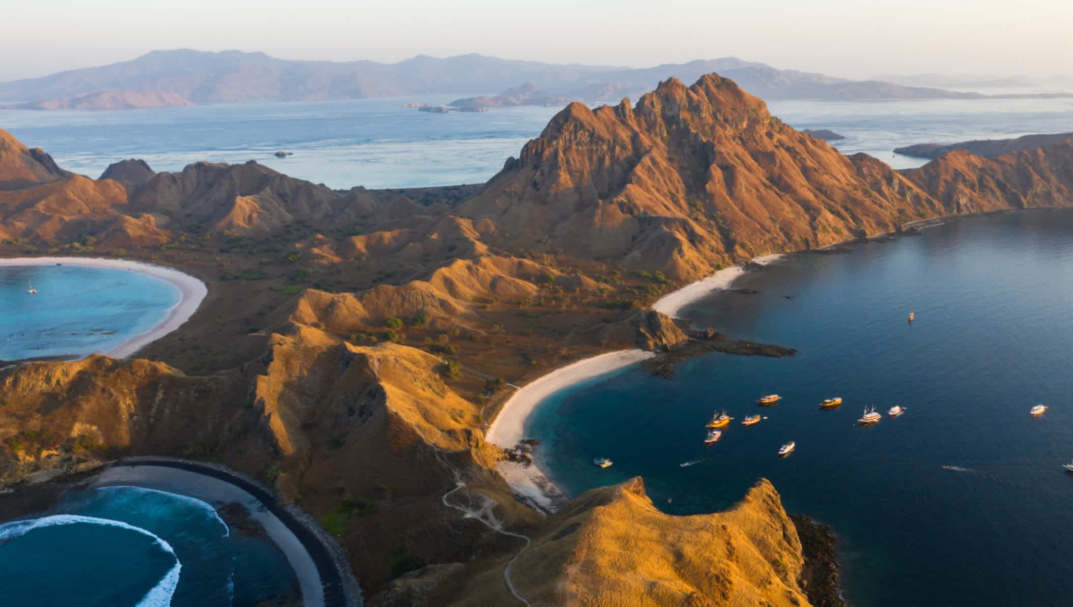 L'île de Padar au coucher du soleil avec des bateaux ancrés dans la baie, Indonésie