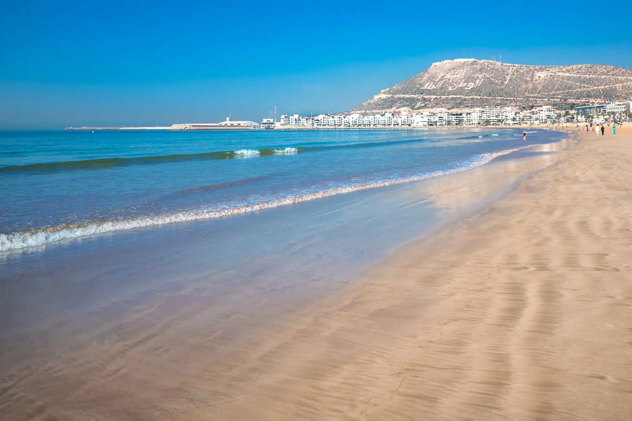 Agadir Strand an der atlantischen afrikanischen Küste im Sommer mit gelbem Sand und türkisfarbenem Wasser in Marokko.

