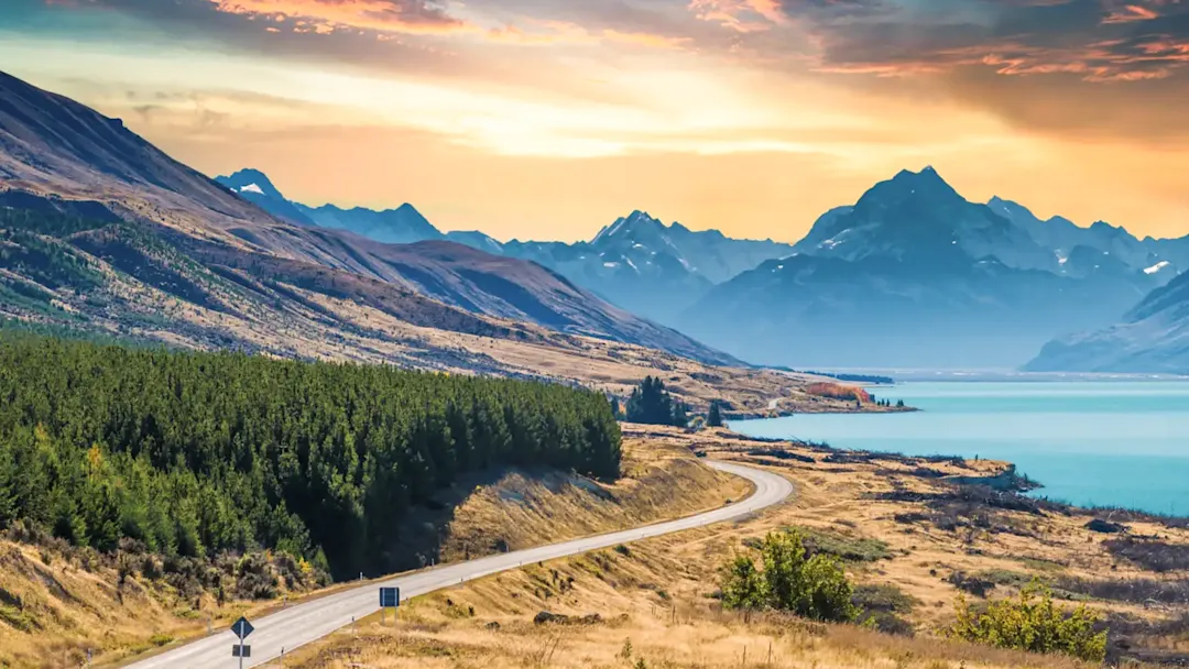 Straße mit Blick auf Berge und See bei Sonnenuntergang. Pukaki, Canterbury, Neuseeland