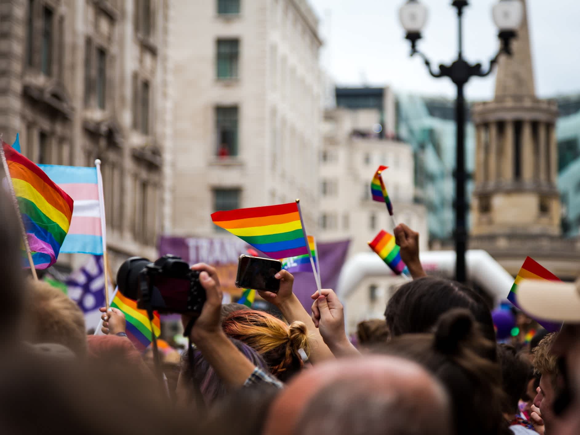 Menschen schwenken Regenbogenflagge bei Gay Pride Parade in London, England. 