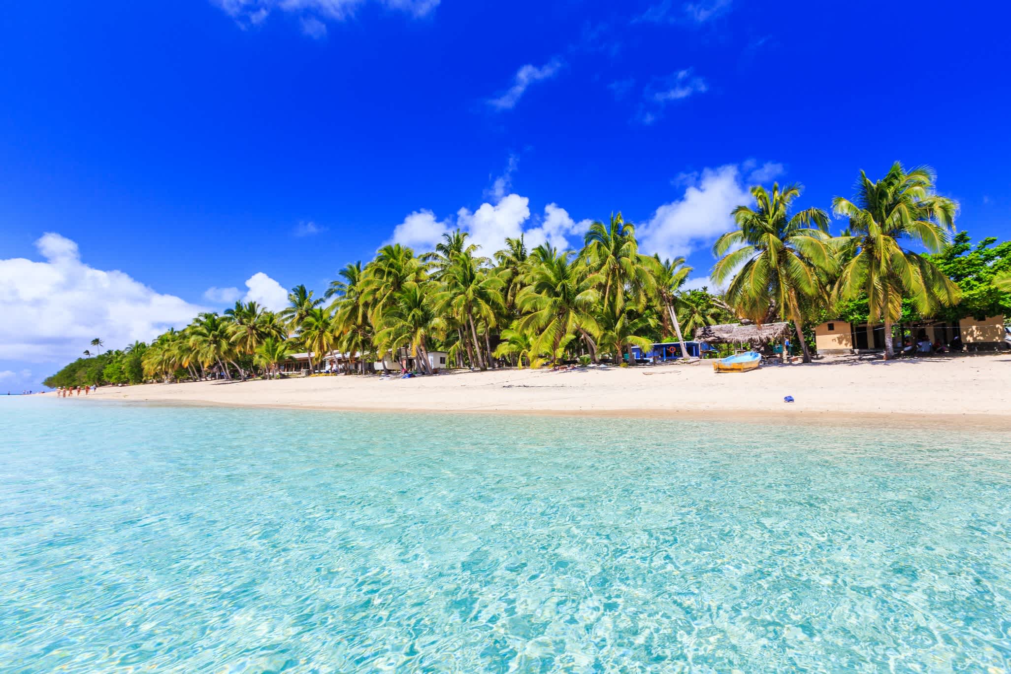 Kristallklares Wasser und Sandstrand mit Palmen