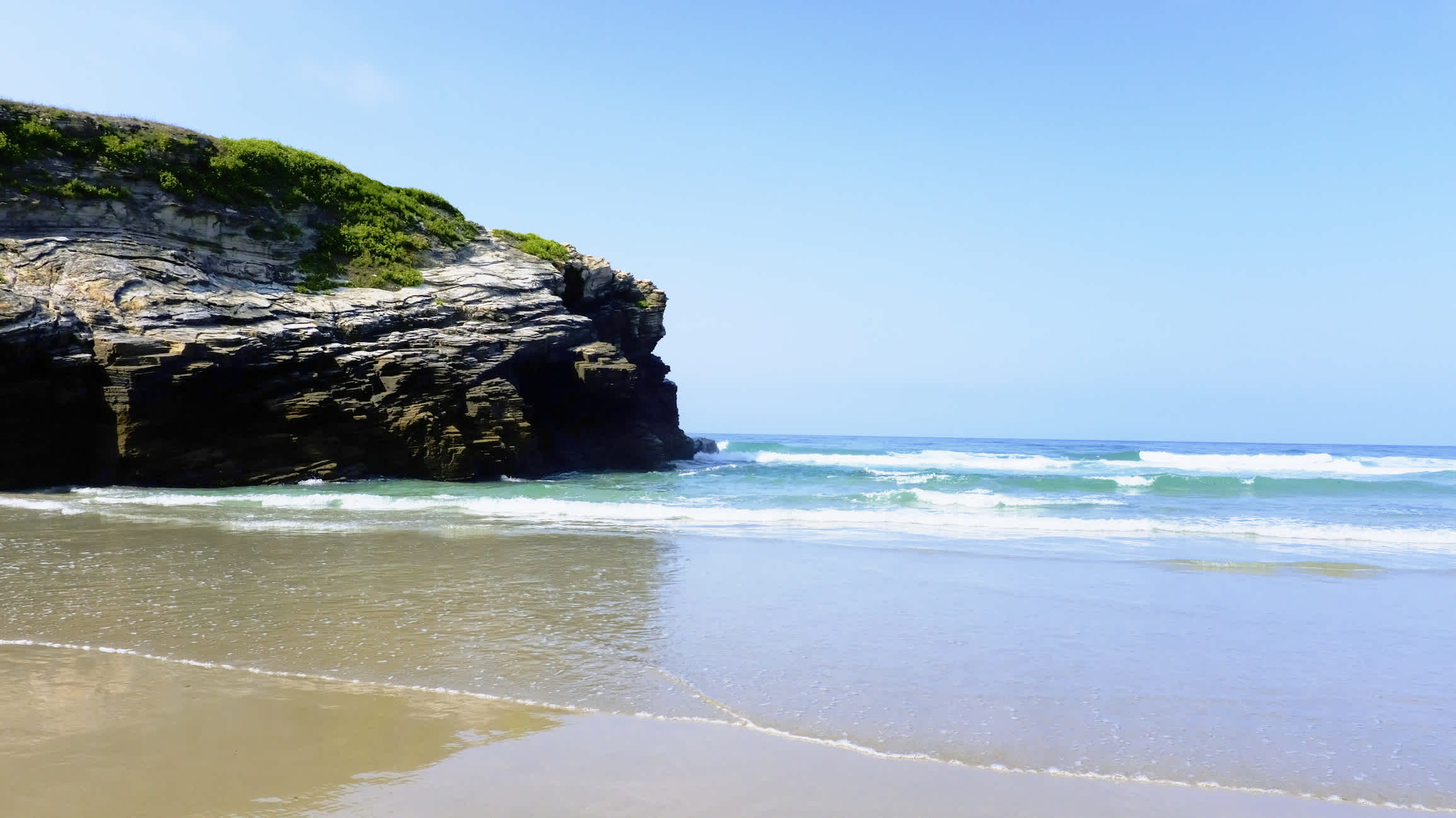 Plage de sable avec un grand rocher au bord de la mer, Plage de Figueiras, Galicie en Espagne