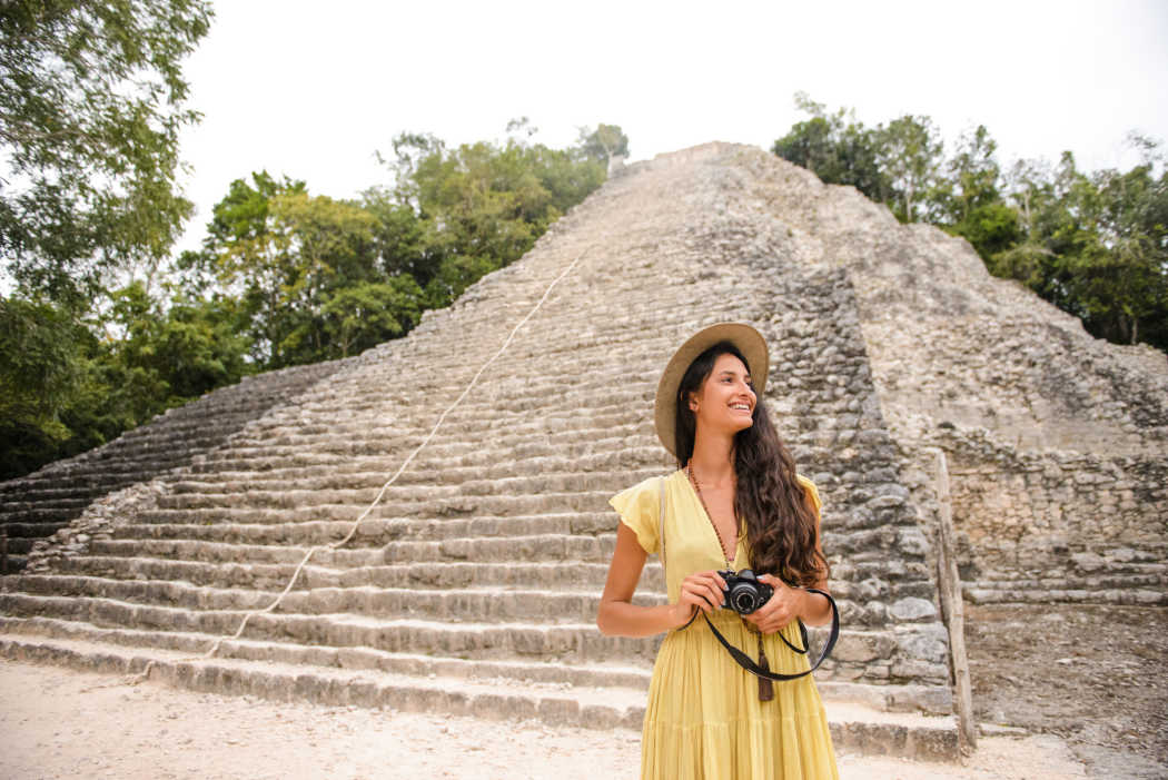 Touristin, die ein Foto von der Coba-Pyramide in Mexiko macht.


