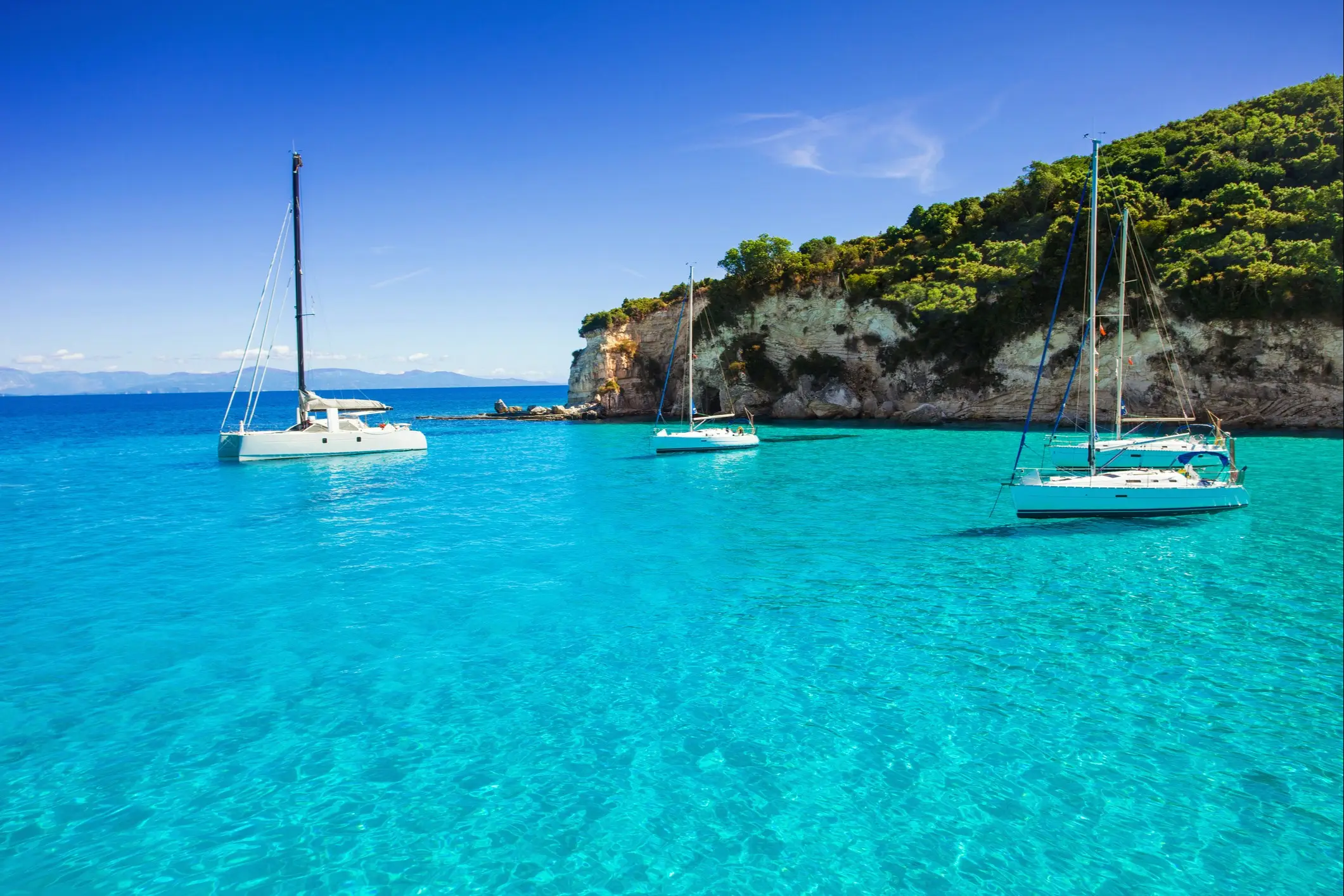 Grèce, Corfou, voiliers Voiliers sur une mer turquoise au bord d'une côte verdoyante