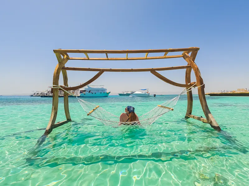 Junge Frau liegt in einer Hängematte auf der paradiesischen Insel in Ägypten.

