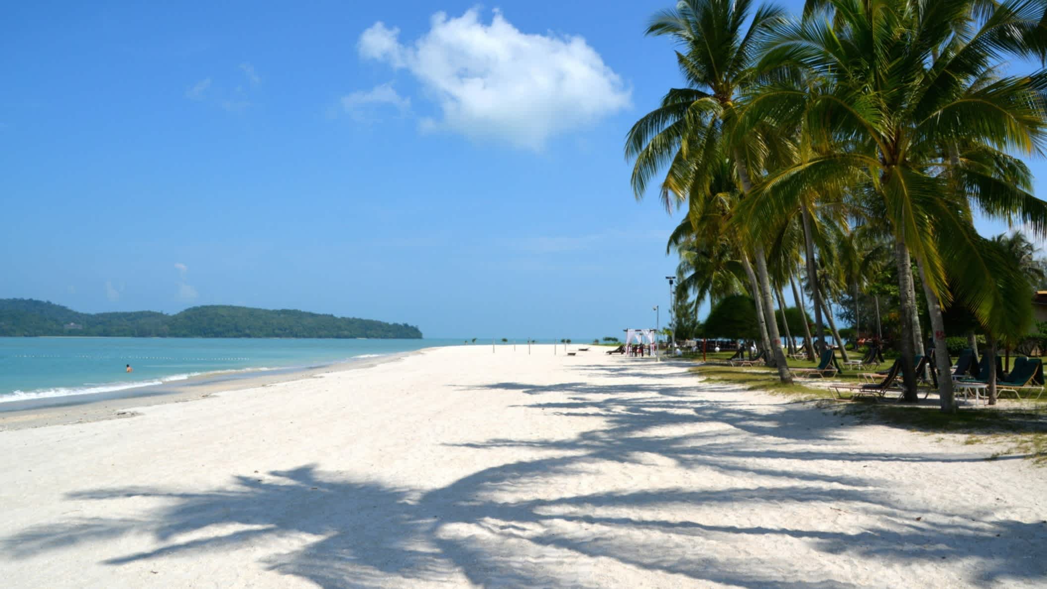 Ombres de palmiers sur le sable blanc de la plage de Pantai Cenang, à Langkawi, en Malaisie. 