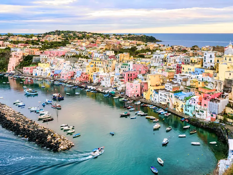 Italien, Kampanien, Procida Bunte Häuser am Hafen mit Booten und ruhigem Wasser. Procida Insel, Kampanien, Italien.
